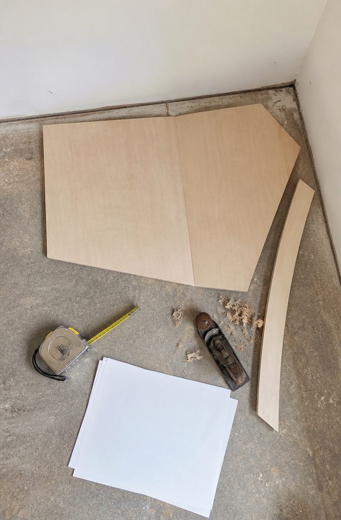 Cabinet layout drawing beside a tape measure and marked wall studs