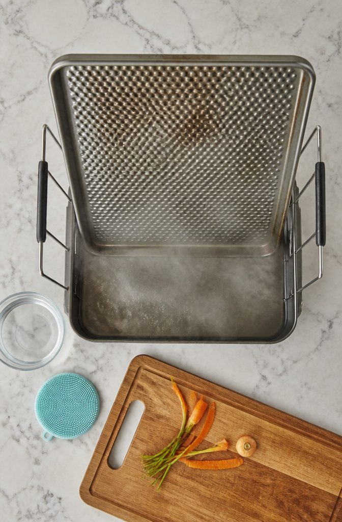 How to Clean Baking Pans: 15 Methods That Work 9 Baking sheet suspended above hot water in a kitchen