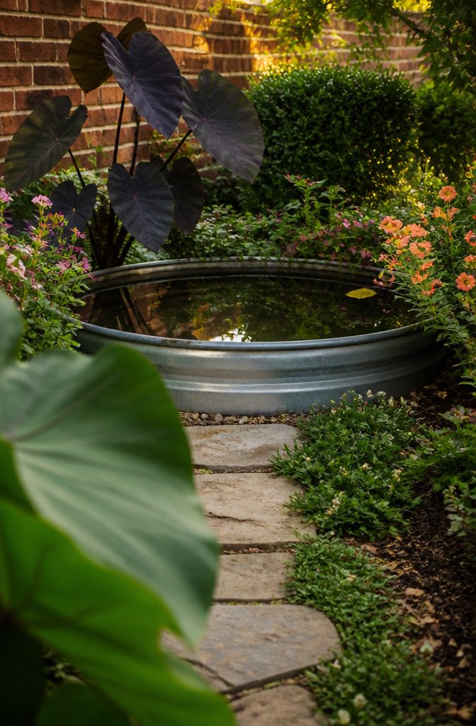 How to Design a Small Garden Space: 20 Ideas That Work 16 Small garden fountain among leafy plants beside a patio
