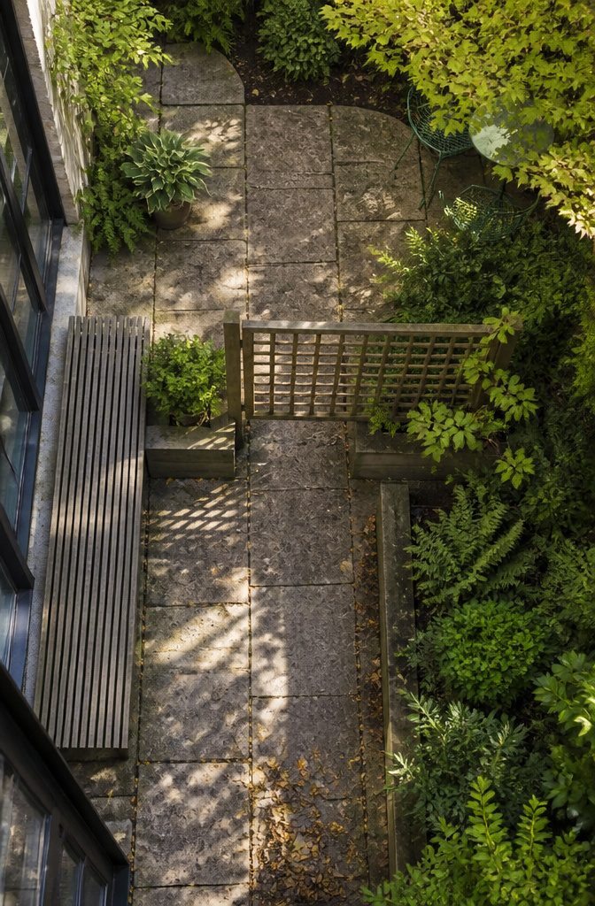 How to Design a Small Garden Space: 20 Ideas That Work 8 Garden divided by trellis screening and tall plants beside a path