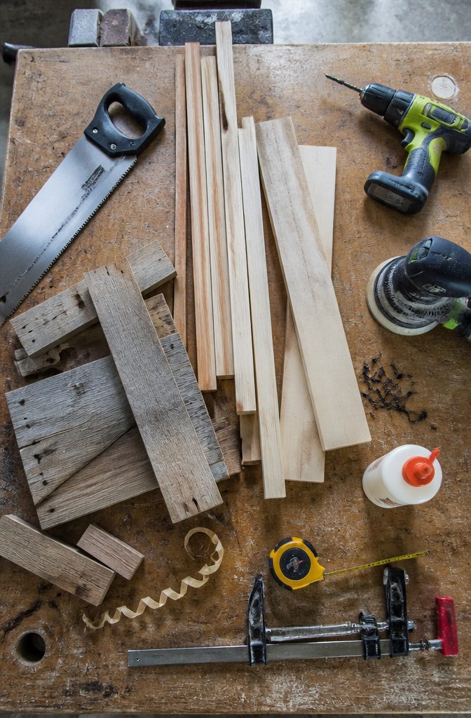 Wood boards and square pieces arranged with tools for making a lantern